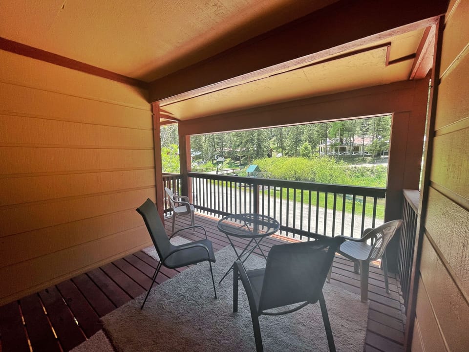Relax on your private covered patio with comfortable seating and tranquil views of lush greenery and surrounding trees—perfect for morning coffee or evening unwinding.