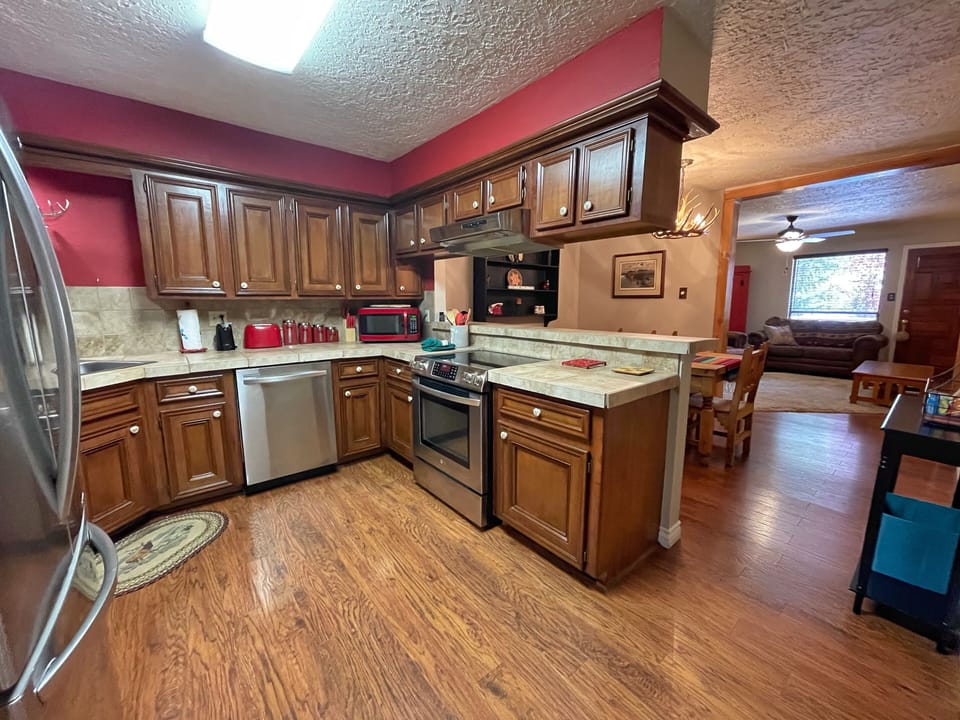 Gather around this spacious kitchen with warm wood cabinetry, stainless steel appliances, and a welcoming center island—your home base for preparing memorable meals together during your stay.
