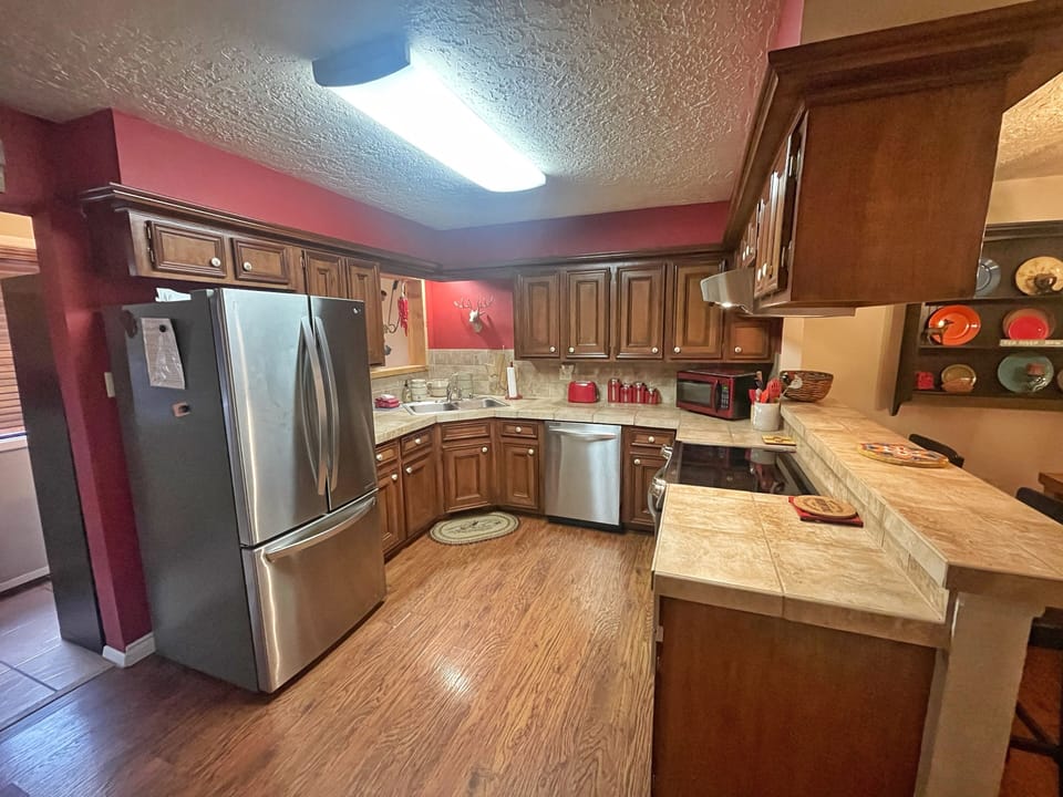 Step into your fully equipped kitchen with stainless steel appliances, ample counter space, and warm wood cabinetry—perfect for whipping up your favorite meals during your stay.