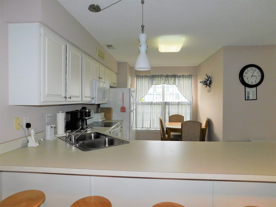 33 Thistle Lane - Breakfast Bar Seating - View of the kitchen's breakfast bar with wooden stools, offering additional seating for quick bites or morning coffee.