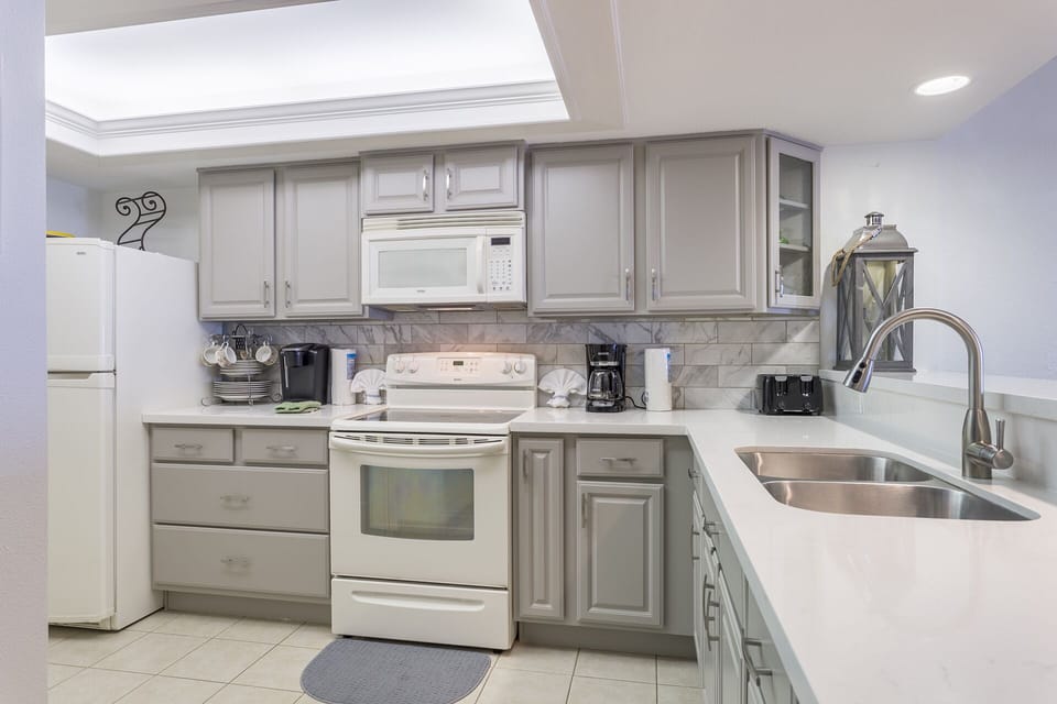 Updated kitchen is equipped with all appliances and is fully stocked with pots, pans, cooking utensils, and dish ware