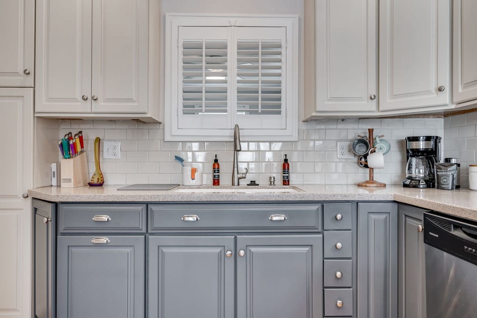 Whip up your favorite meals in this elegant kitchen featuring two-toned cabinetry, granite counters, and modern appliances.