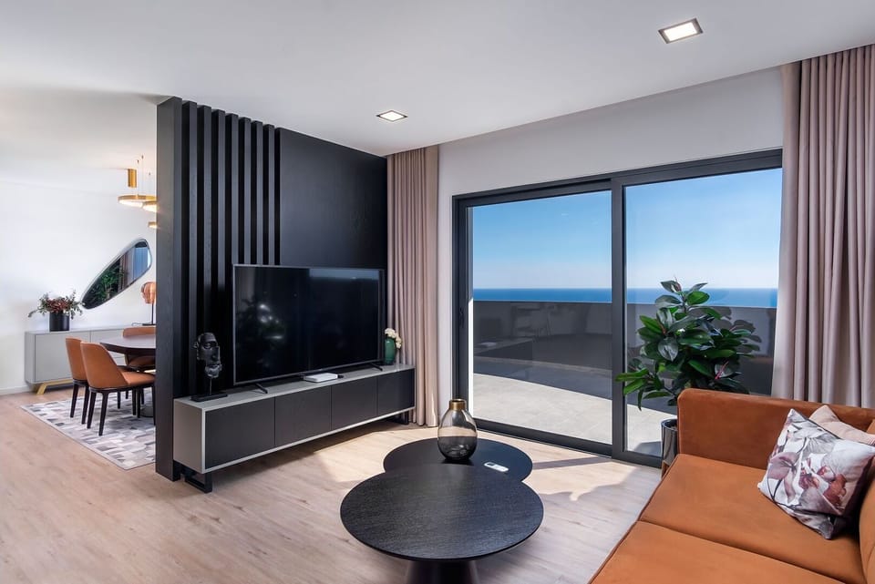 Sophisticated living room with direct access to outdoor areas, combining comfort, style, and stunning views. #LuxuryInteriors #RelaxInStyle #HolidayHome