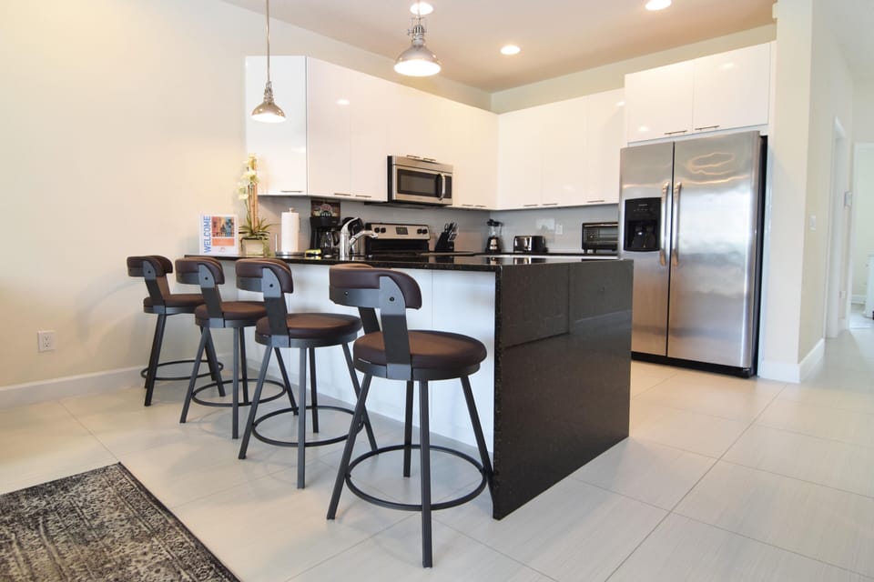 Modern kitchen with stainless steel appliances, granite counters, breakfast bar 