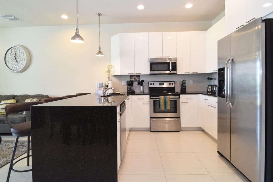 Modern kitchen with stainless steel appliances, granite counters, breakfast bar