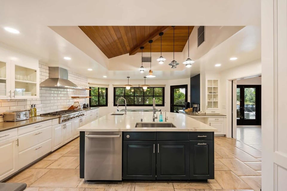 Gorgeous kitchen with a blend of dark and light tones, featuring unique wood accents that bring warmth to the home.