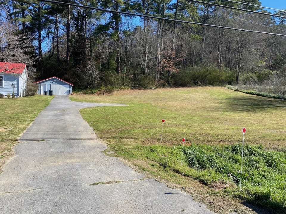 Long driveway and grassy parking area to the right