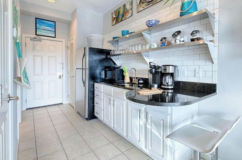 Cook your favorite meals in this bright, fully-equipped kitchen with sleek granite counters and modern appliances.