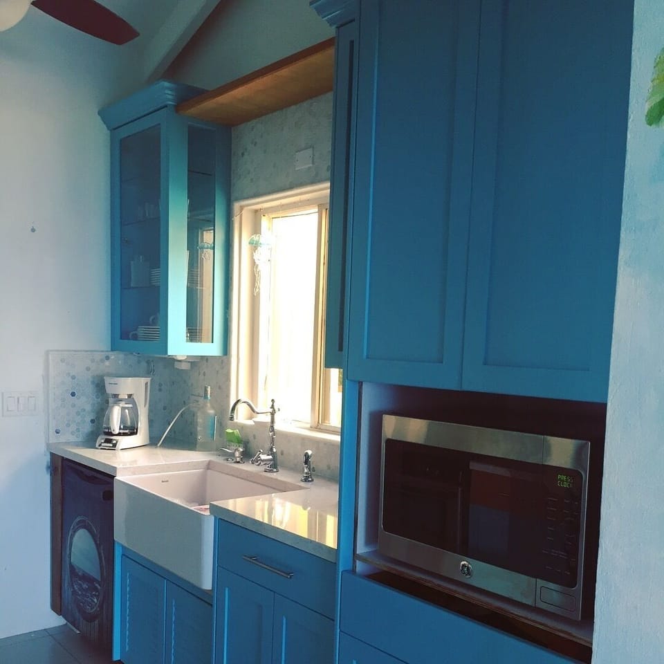 Turquoise Paint and Teak Stained Custom Kitchen Cabinets, marble tile finishes.