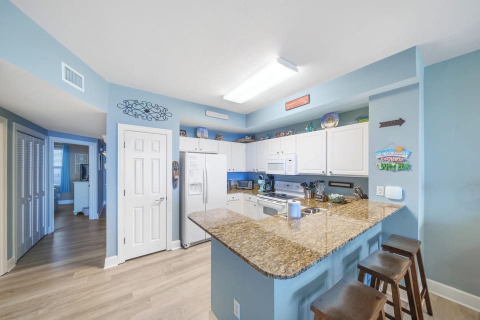 Granite kitchen countertops with seating for 3 at the bar.