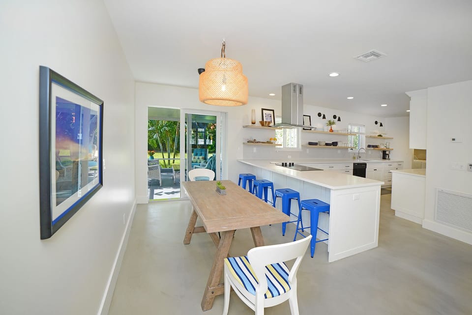Seating at the dining table as well as at the island peninsula.  View to outdoor