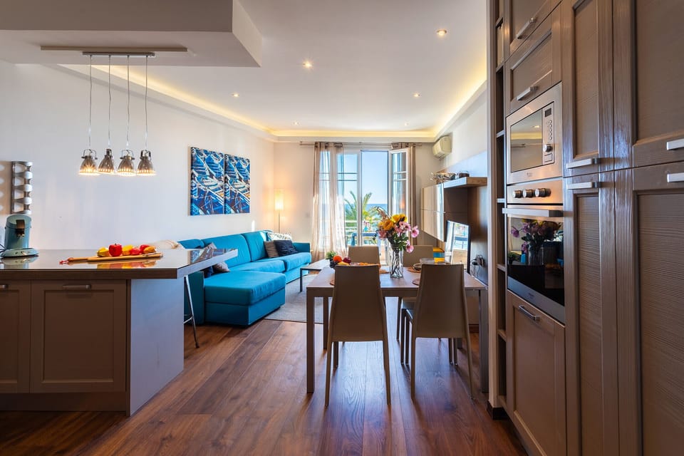 A bright living space with a modern kitchen and cozy lounge, ideal for gatherings. Large windows offer lovely views.