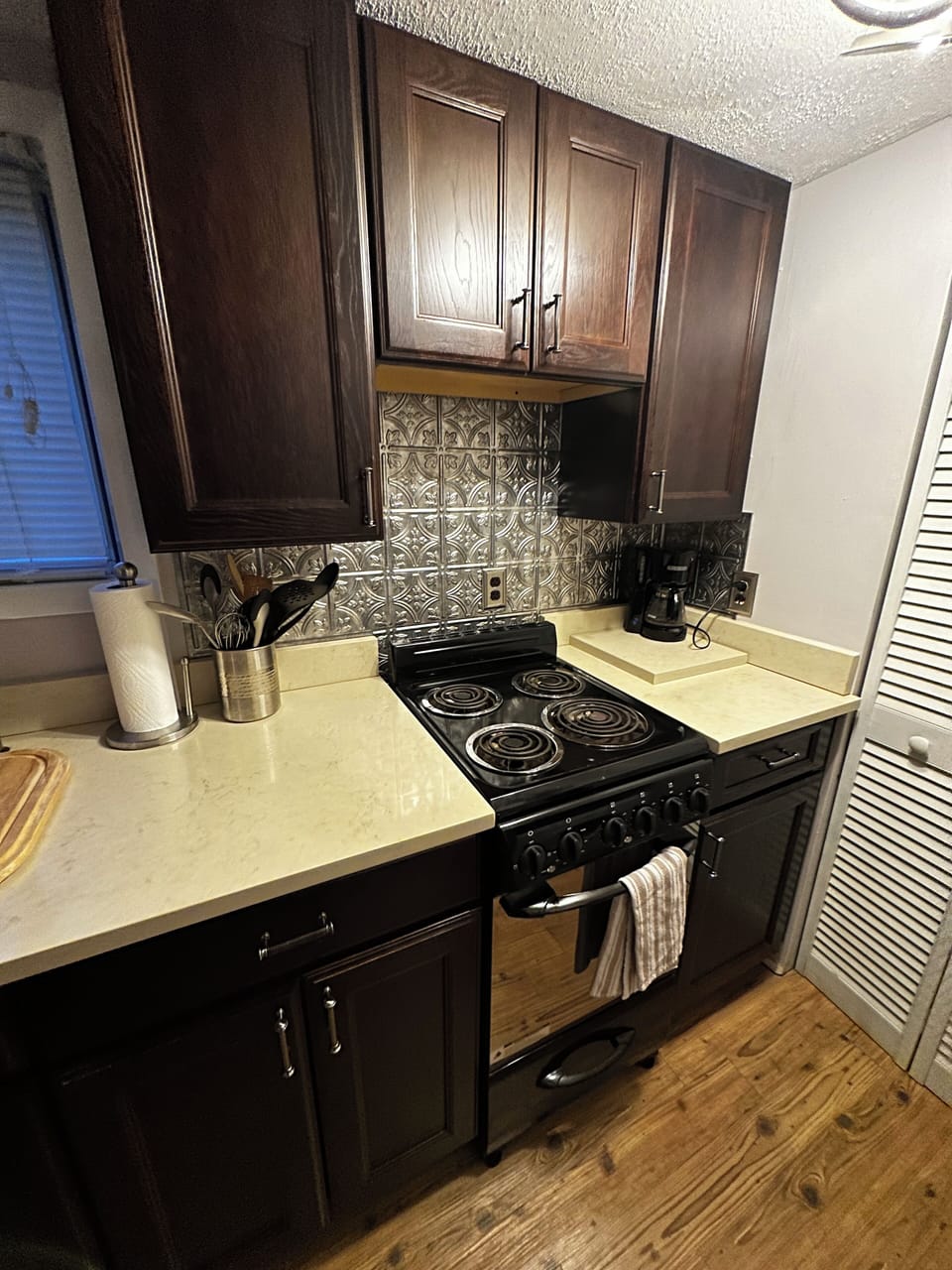 kitchenette with oven/range, sink, stocked with cooking/dining essentials.