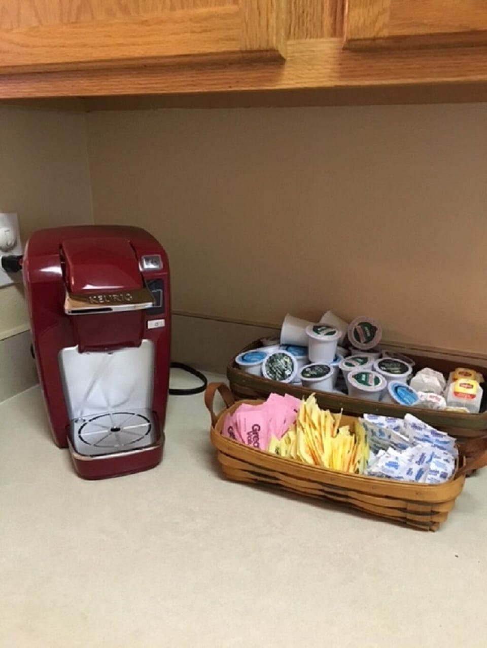 Single serve Keurig with starter supply of K-cups and sweeteners.
