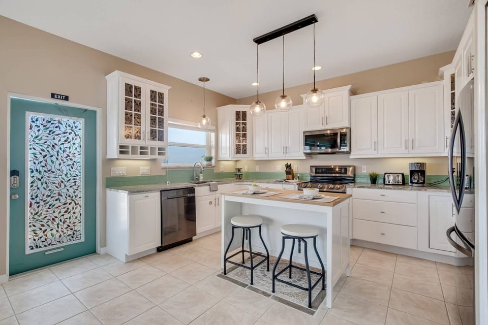 Fully equipped kitchen featuring an oven, stove, island, dishwasher, toaster, microwave, and coffee maker for your convenience.