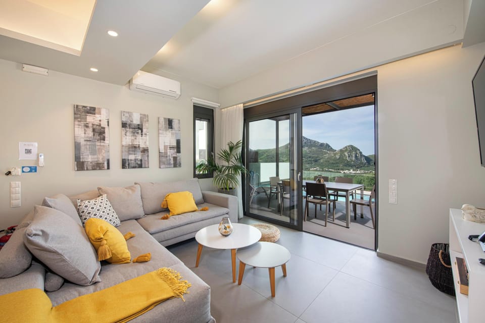 The living room features a large corner sofa, a 55’’ Smart HDTV with Netflix App, a bluetooth speaker and a coffee table