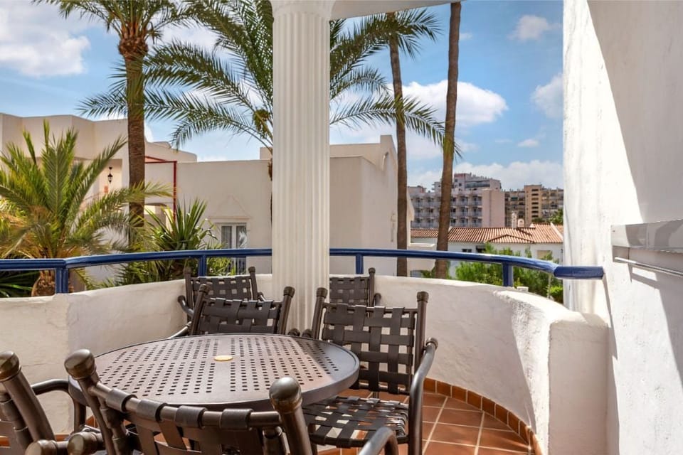 Covered balcony with comfortable seating, offering a private outdoor space to dine and relax.