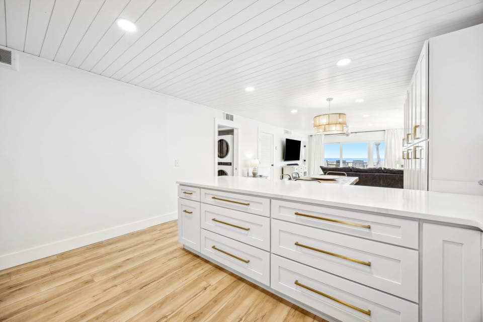 Your gourmet kitchen features pristine white cabinetry, gleaming quartz countertops, and warm hardwood floors that invite you to cook memorable meals.