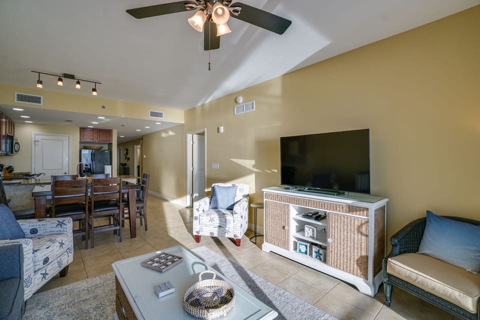 Unwind in your bright, open-concept living space with comfortable seating, large TV, and coastal decor throughout.