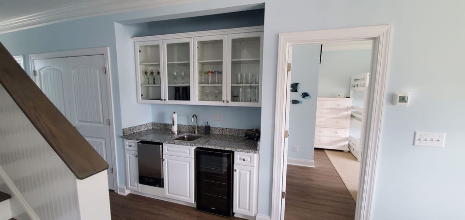Downstairs wet bar with beverage cooler and ice maker.