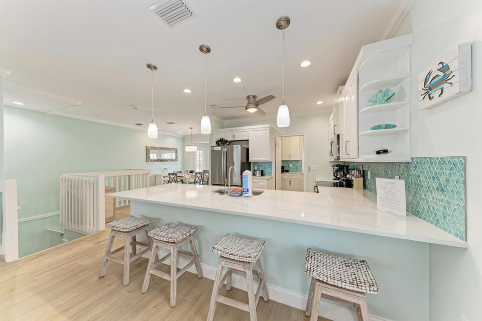 Gather around this bright coastal kitchen where ocean-inspired tiles and beachy décor set a relaxed tone for your morning coffee or easy meal prep together.