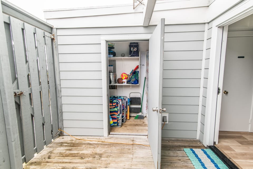 Shed in courtyard off kitchen with outdoor shower and beach equipment
