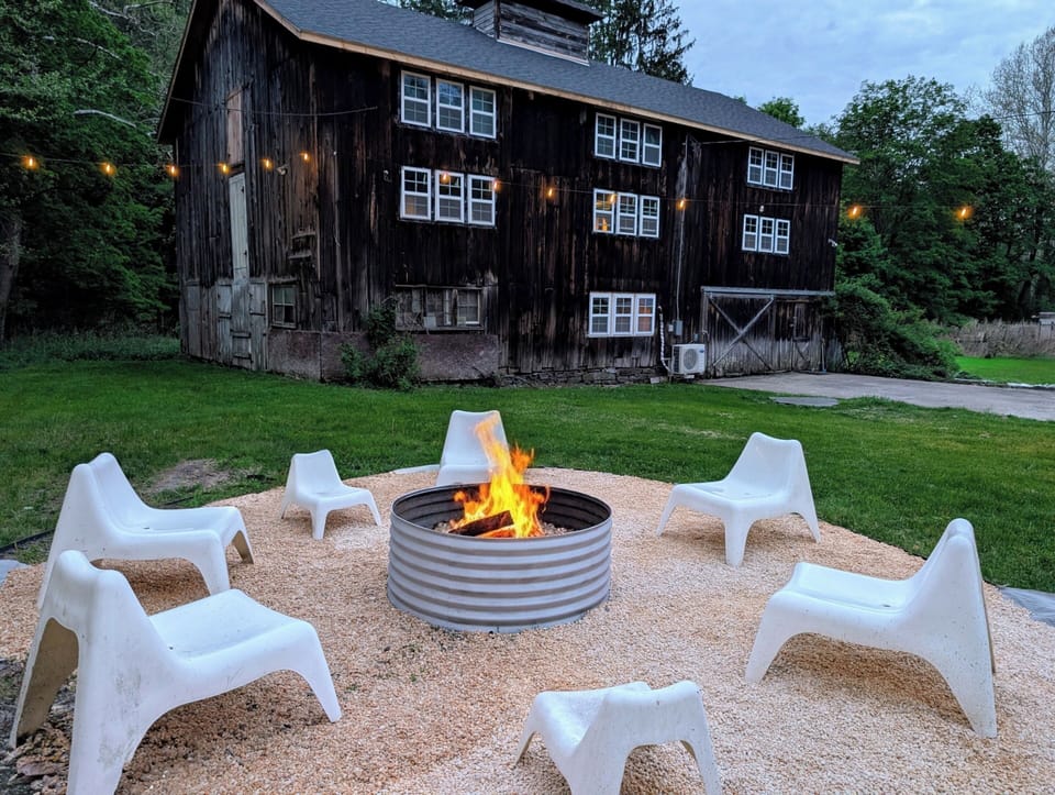 The fire pit is is located between the house and the barn.