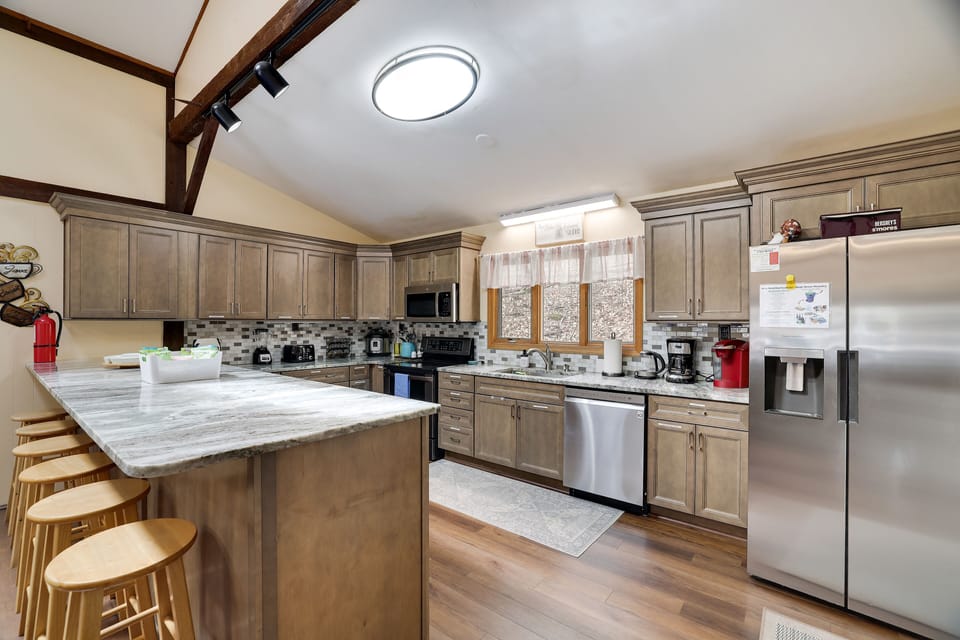 Newly renovated, fully stocked kitchen with granite counters and bar stools 