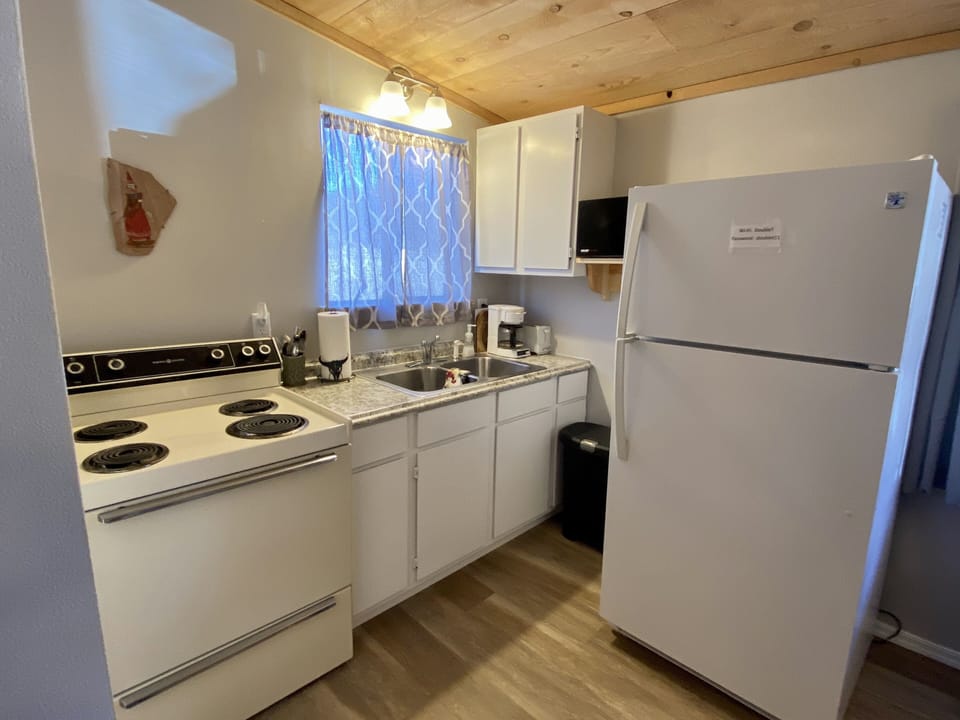 Full Kitchen with refrigerator, stove/oven, microwave, coffee pot, and toaster