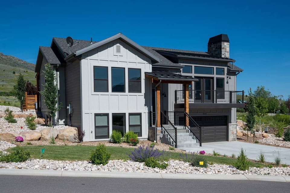 View of the front of the house, featuring front deck, a two car garage and plenty of parking.