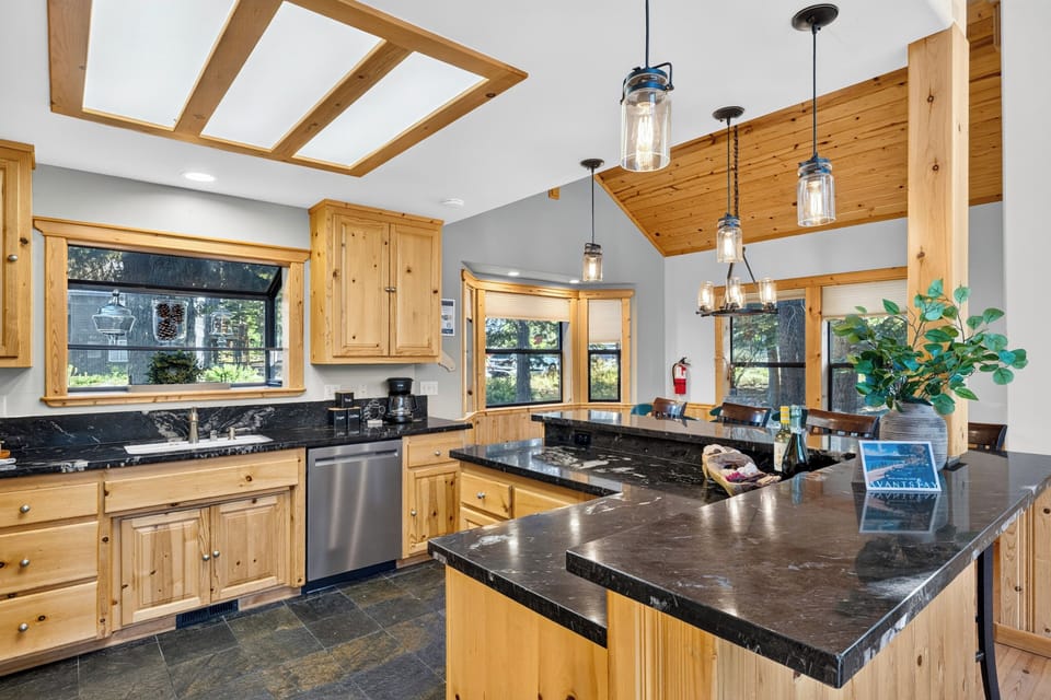 Lodge-style kitchen with pine cabinetry, black stone counters, and a breakfast bar for easy meals.