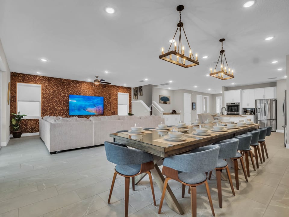 - Spacious living and dining room perfect for large group gatherings  
- Modern open layout with long dining table and stylish seating  
- Large wall mounted TV for relaxing movie nights together