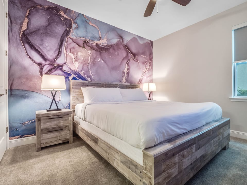 - Bedroom with rustic wood furniture and artistic accent wall design  
- Comfortable queen bed ensures restful sleep during vacation stays  
- Unique wall mural adds style to the Airbnb guest experience
