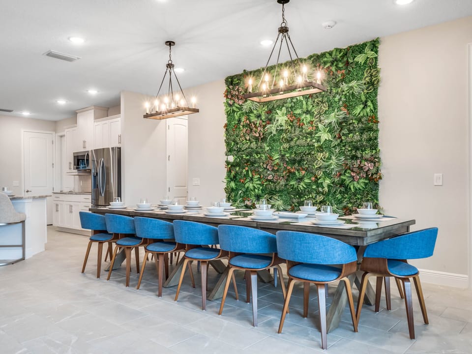 - Elegant dining area featuring a full greenery accent wall  
- Long table setup ideal for family dinners and celebrations  
- Modern lighting and seating add style to the vacation home