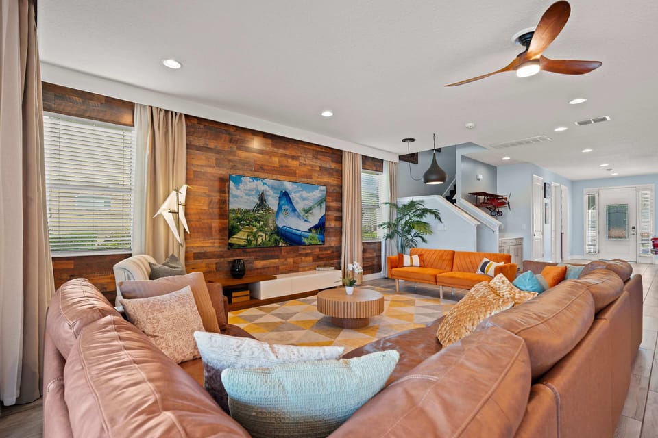 - Modern living space with sectional sofa and colorful accents  
- Smart TV entertainment wall framed by rustic wood finishes  
- Comfortable seating designed for family and group relaxation