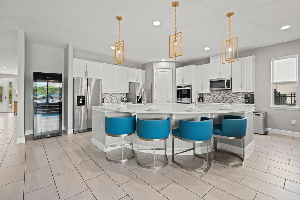 - Stylish kitchen with island seating and blue barstools  
- Stainless steel appliances and double ovens for use  
- Family friendly vacation home with modern kitchen