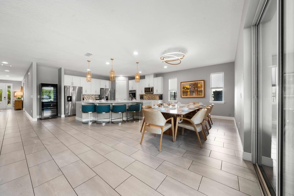 - Bright open layout with dining and kitchen combined  
- Long table and modern lighting perfect for gatherings  
- Orlando vacation rental designed for group stays