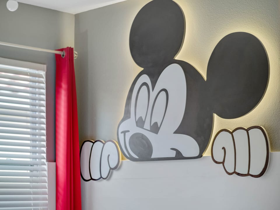 - Mickey Mouse inspired wall art with glowing fun design  
- Bright colors and playful accents create cheerful bedroom  
- A magical touch kids enjoy while staying near Disney parks