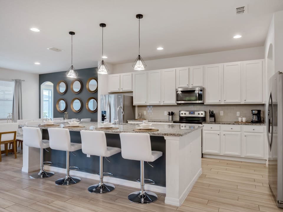 - Modern kitchen with granite counters and stainless appliances  
- Large island with seating for four connects to open floor plan  
- Perfect space for cooking and gathering with family and friends