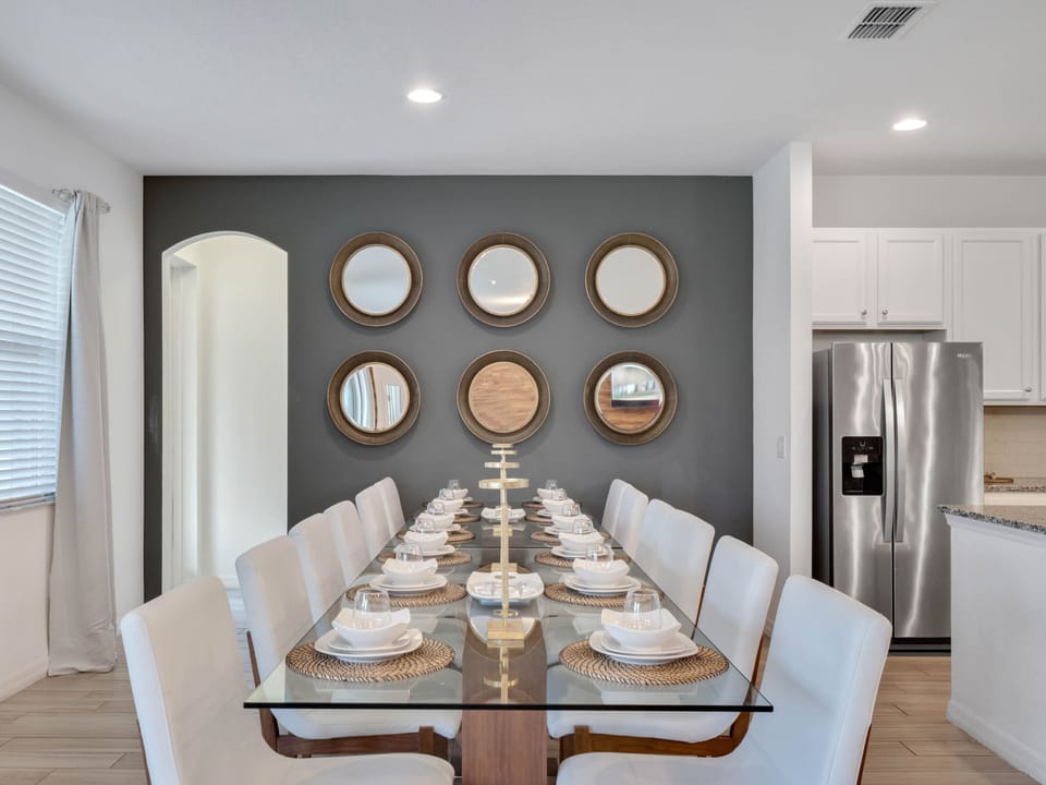 - Glass top dining table seats the whole group in one place  
- Comfortable cushioned chairs for long shared meals together  
- Great setup for family dinners or hosting friends in Orlando