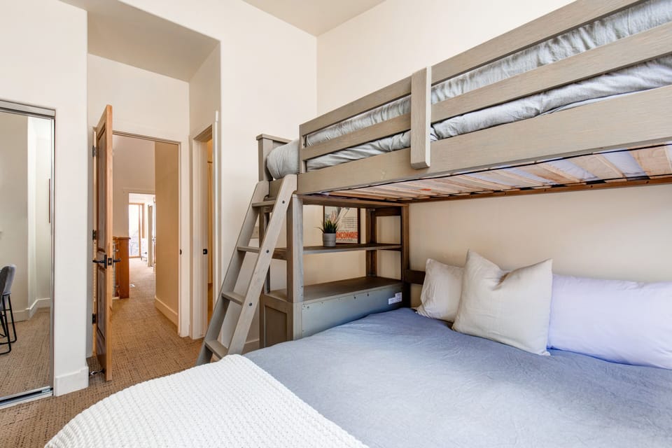 Upper Level Bedroom Two with twin over queen bunkbed, built-in storage, 43" Vizio tv, work desk, and en suite bathroom