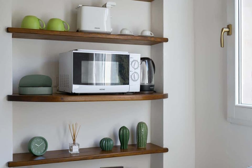 Particolare di accessori su angolo cottura: Forno a microonde, Tostapane e  Bollitore.