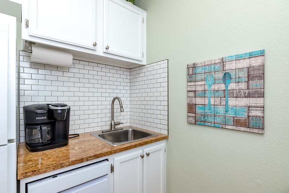 Start your mornings right in your charming kitchenette with fresh coffee from the Keurig, granite counters, and cheerful coastal artwork.