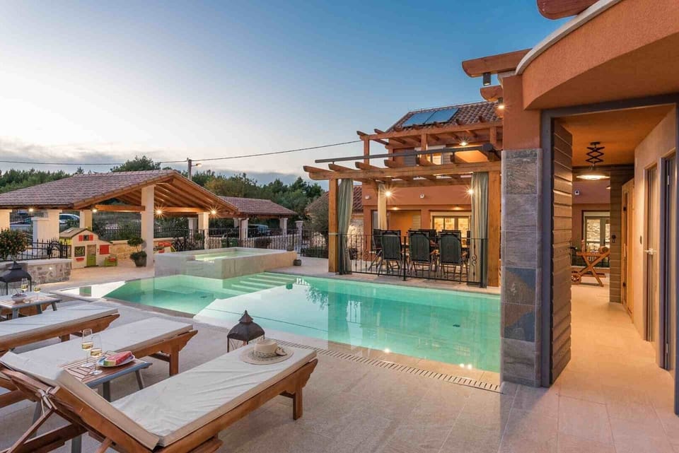 Deck chairs by the pool of a luxury vacation villa with concierge service and private parking in Skradin