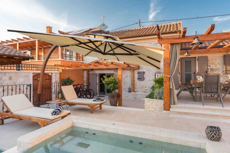 Deck chairs by the pool of a Croatian luxury vacation villa with concierge service and private parking in Skradin