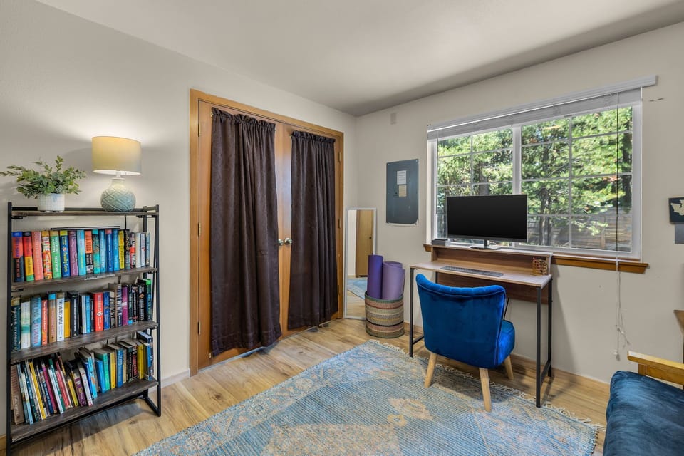 Settle into your own quiet workspace with inspiring garden views through the window. A cozy reading nook awaits with curated books and warm lighting.