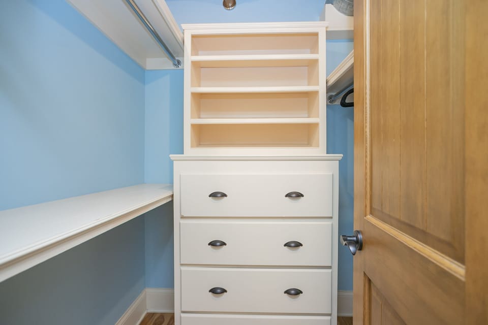 - Walk-in closet with built-in drawers and shelving in Nashville   - Bright blue walls and ample hanging space for easy storage   - Perfect for extended stays and organized travel