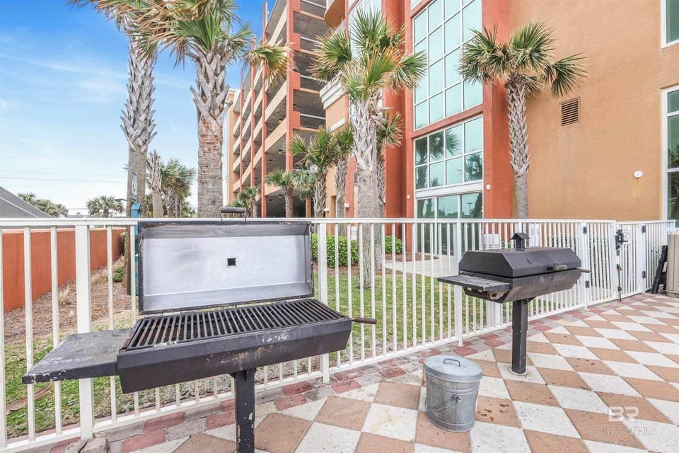 2 BBQ Grills, Fenced Area, Stone Patio, Palm Trees, Complex Parking Deck.