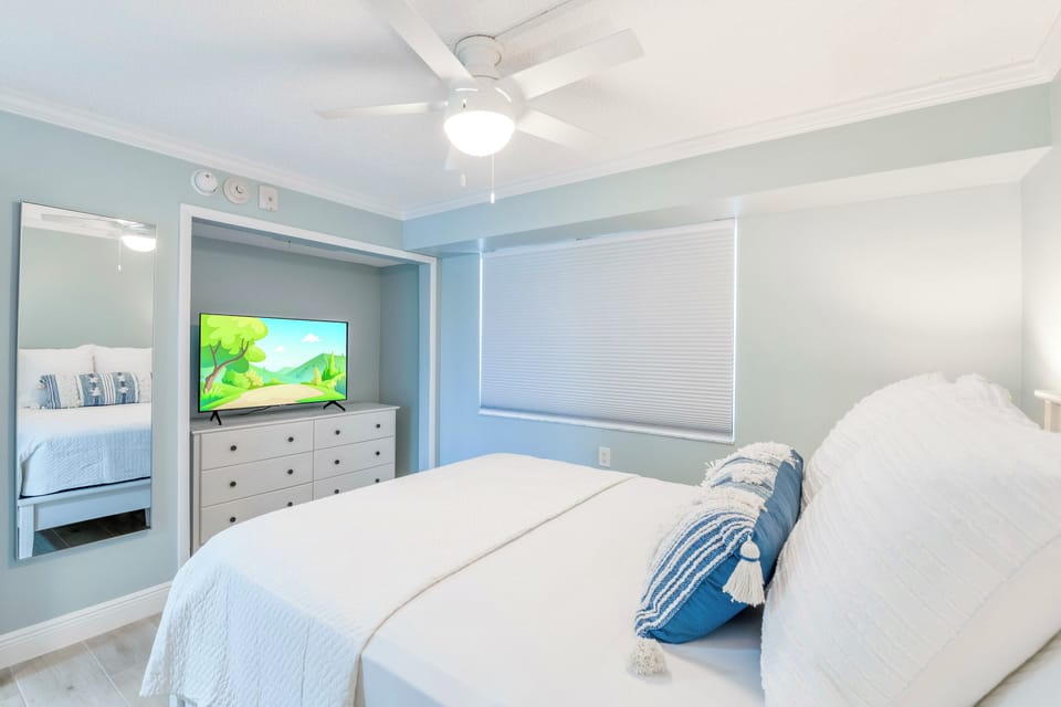 Guest bedroom with queen sized bed and flat screen TV.