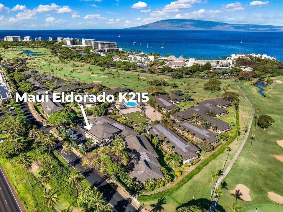 Aerial view of Maui Eldorado framed by lush golf course greens and shimmering ocean views